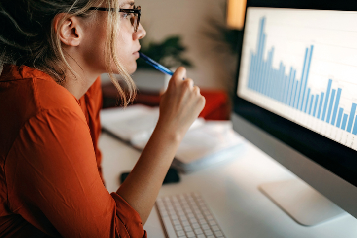 Woman looking at a computer screen displaying a bar graph