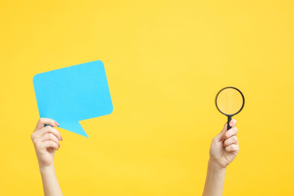 speech bubble and magnifying glass against yellow background